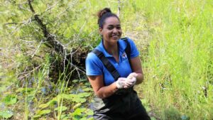 Patricia Wilson holding a map turtle hatchling, a species at risk
