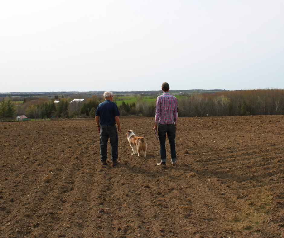 Bruce Kidd and Thom Unrau on tilled farmland at Kidd Farm CEA