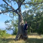 CCC intern Melanie Beaulieu standing beside tree at Hammer Family Nature Preserve