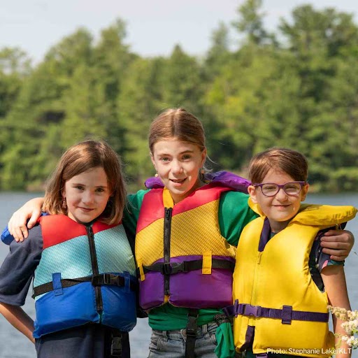 Children standing beside Stoney Lake